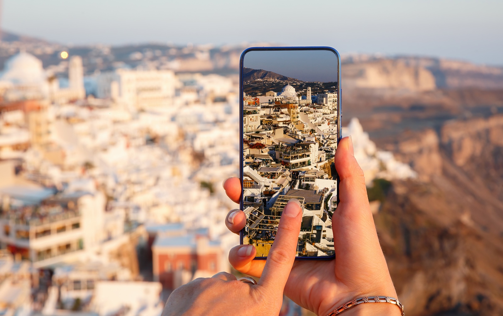 Tomar fotograf&iacute;as a trav&eacute;s de un tel&eacute;fono m&oacute;vil en la isla de Santorini, Grecia.