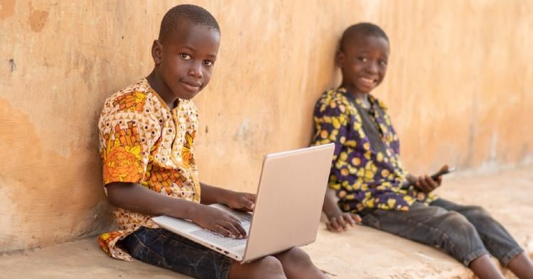 niños con un ordenador y movil niños con un ordenador y movil