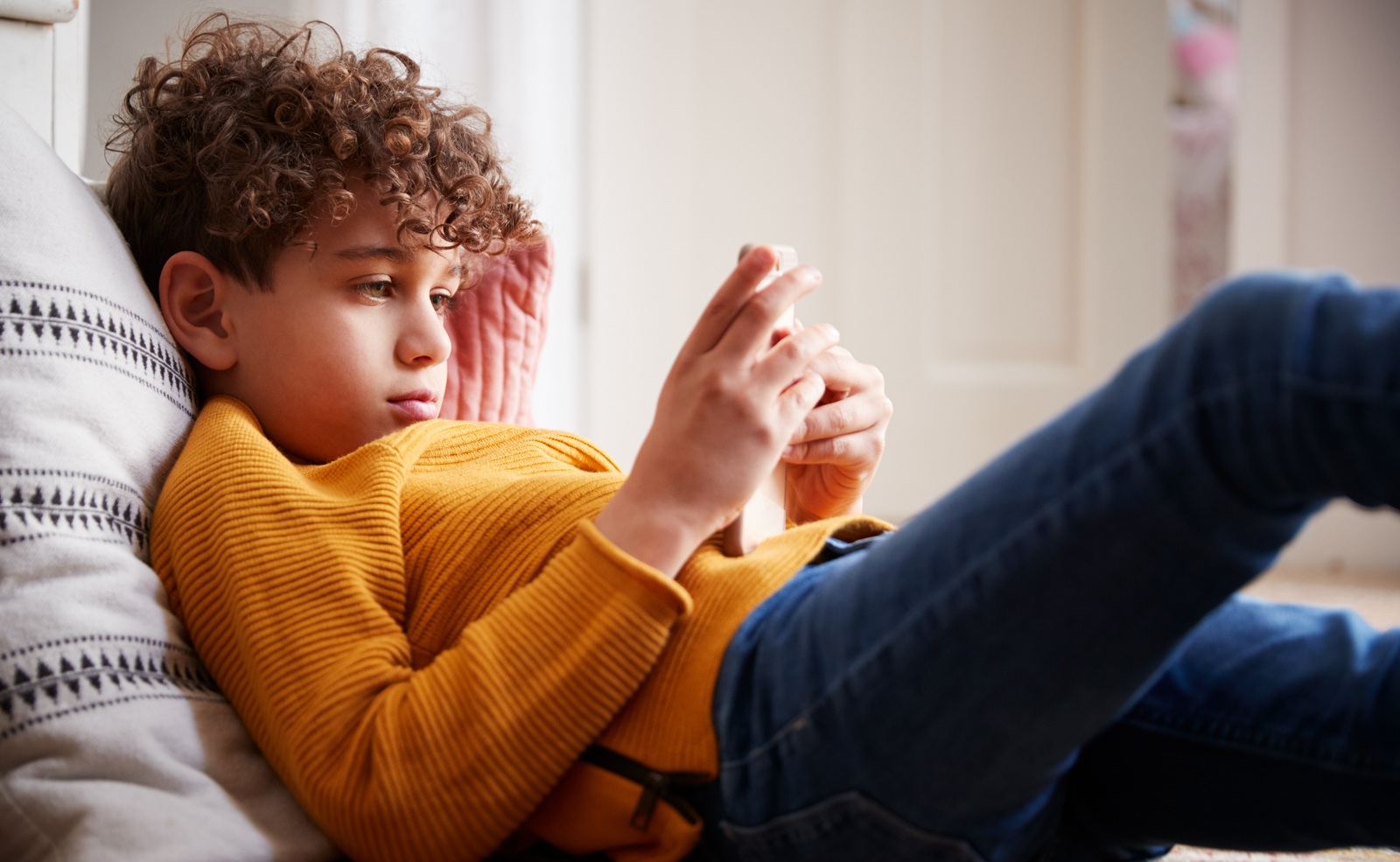 ni&ntilde;o con el movil en la cama