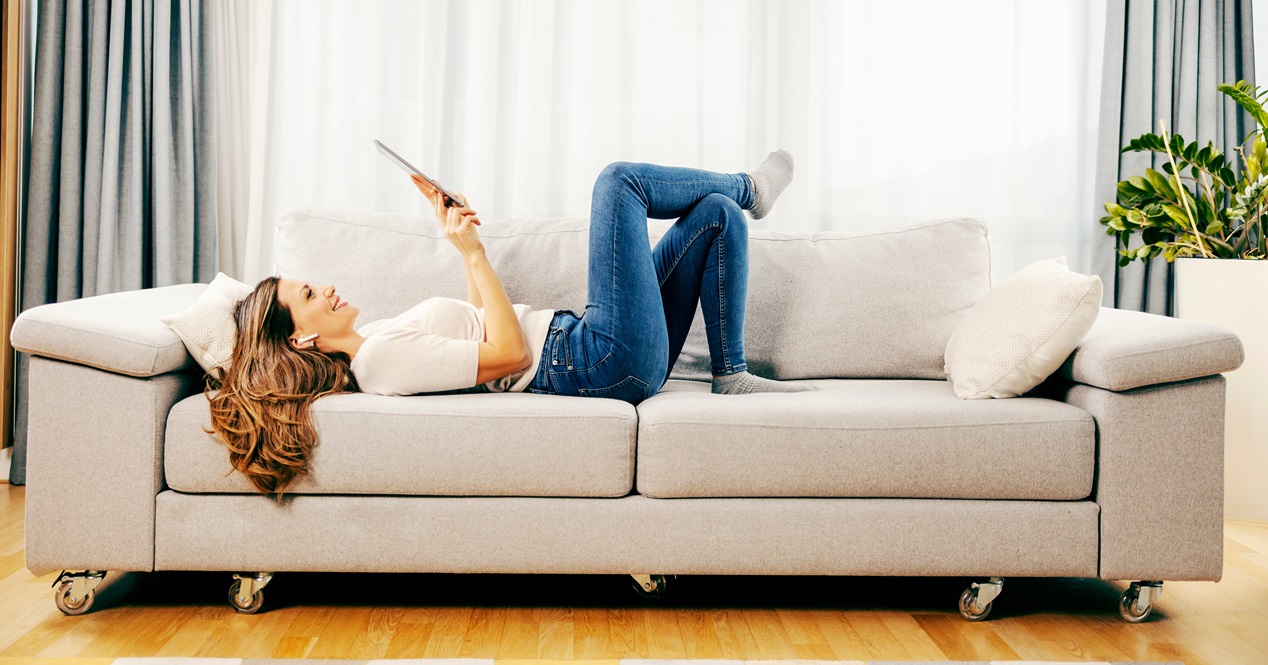 mujer viendo una tablet en el sofa