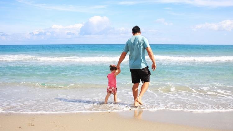 padre e hija en la playa empresario de vacaciones